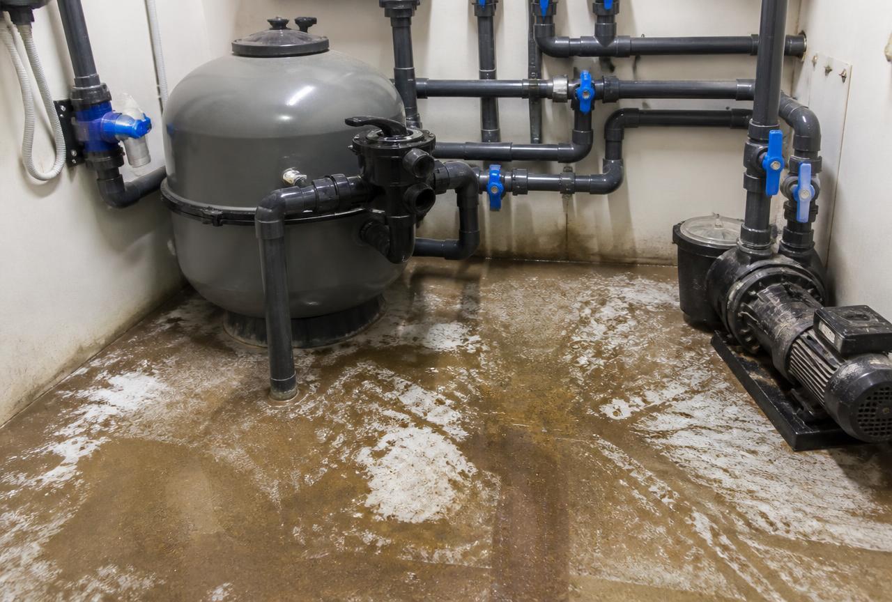 Local technique de piscine avec eau au sol lors d'une recherche de fuite à Rueil-Malmaison